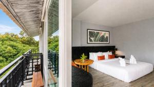 a bedroom with a bed and a balcony at JALMIN Hotel Samui in Chaweng