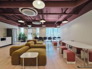 a living room with couches and tables and chairs at Seoul ABC Hostel in Seoul