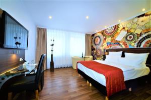 ein Hotelzimmer mit einem Bett und einem Schreibtisch in der Unterkunft Ascot Hotel in Remscheid