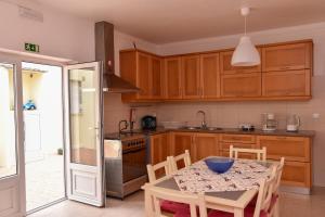 a kitchen with wooden cabinets and a table with a bowl on it at Surf House Helena in Baleal