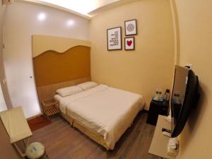 a bedroom with a bed and a flat screen tv at I WoW in Xiaoliuqiu