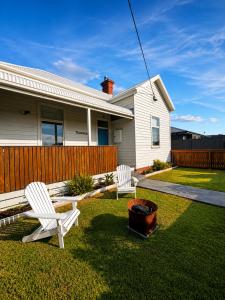 two white chairs in the yard of a house at The Guesthouse in Terang