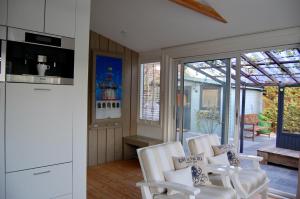 ノールトウェイク・アーン・ゼーにあるPlace2BEach-Bungalowのリビングルーム(白い椅子2脚付)、キッチン