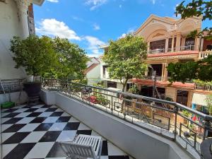 a balcony of a building with a checkered floor at Rose's Homestay Hue in Hue