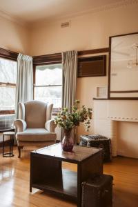 a living room with a vase of flowers on a coffee table at Warburton Stays Grand View in Warburton