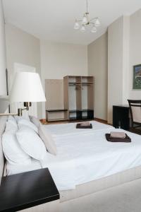 a large white bed with white pillows and a lamp at Mini-Hotel Under The Roof in Lviv