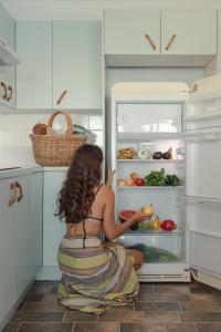 a woman sitting in front of an open refrigerator at Bay Properties Pacific Lodge in Yamba +21 photos