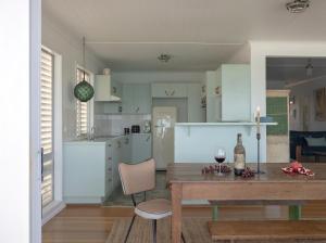a kitchen and living room with a table and a dining room at Bay Properties Pacific Lodge in Yamba