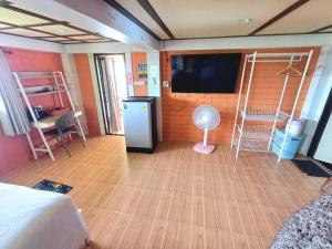 a room with a bedroom with a fan and a tv at Magic View Apartments Koh Tao in Ko Tao