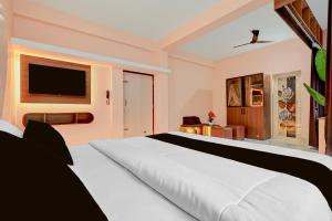 a bedroom with a white bed and a flat screen tv at Hotel O Bhubaneswar New Station Road in Bhubaneshwar +29 photos