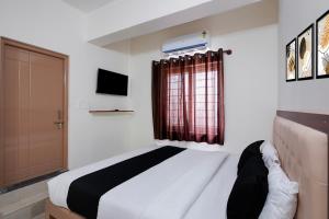 a bedroom with a bed and a window at Super Hotel O Phase 2 Christ Nagar Bangalore in Bangalore +24 photos