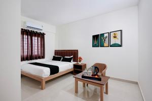 a bedroom with a bed and a table at Super Hotel O Phase 2 Christ Nagar Bangalore in Bangalore