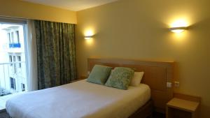 a bedroom with a bed with two pillows and a window at Residence Club Inn in Nice
