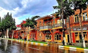 a person walking down a street in front of a brick building at Northern City Hotel in Zaqatala