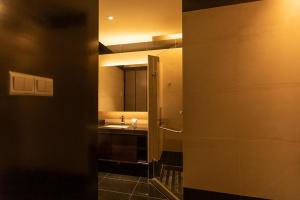 a room with a bathroom with a sink and a mirror at New World Suites in Bintulu +21 photos
