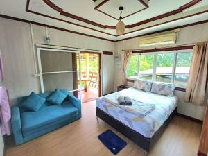 a bedroom with a bed and a blue couch at Koh Tao Townhouse in Ko Tao