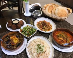 a table with plates of food and bread and rice at Aura Grand pyramids view inn in Giza
