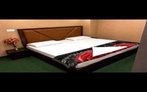 a bedroom with a bed with white sheets and avertisement at Hotel O Sky Rooms in Jammu