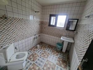a bathroom with a toilet and a sink at Hotel O Sky Rooms in Jammu