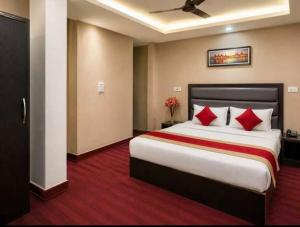 a hotel room with a large bed with red pillows at Hotel O Sky Rooms in Jammu