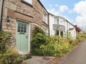 a brick house with a green door on a street at The Orchard in Kendal
