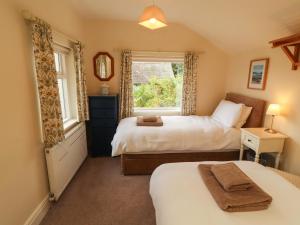 a bedroom with two beds and a window at The Orchard in Kendal