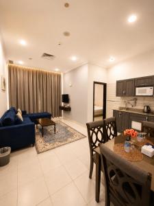 a living room with a blue couch and a table at Atlantis International Hotel Apartments in Kuwait