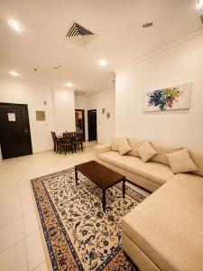 a living room with a couch and a table at Atlantis International Hotel Apartments in Kuwait +33 photos