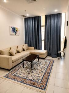 a living room with a couch and a coffee table at Atlantis International Hotel Apartments in Kuwait