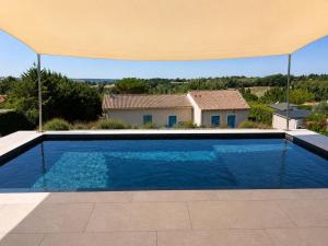 a swimming pool in front of a house at L'Escapade Caramanaise in Caraman