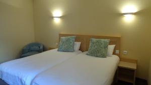 a bedroom with two beds and a blue chair at Residence Club Inn in Nice