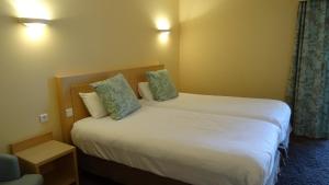 a hotel room with two beds and a chair at Residence Club Inn in Nice