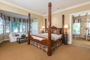 a bedroom with a four poster bed and a couch at Glen Gordon Manor in Huntly