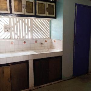 a bathroom with sinks and a blue door and a window at Janisah Pension House in Narra +15 photos