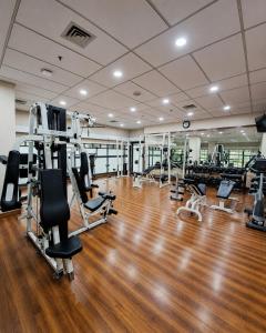 a gym with treadmills and machines in a room at Grand Tropic Suites Hotel in Jakarta