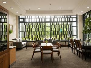 a dining room with a table and chairs and windows at Grand Tropic Suites Hotel in Jakarta