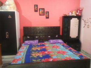 a bedroom with a bed with a colorful comforter at SHYAMSHOBHA NIWAs in Chandauli