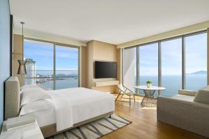 a bedroom with a large white bed and a television at Hyatt Regency Nha Trang in Nha Trang