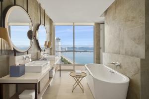 a bathroom with two sinks and a tub and a large window at Hyatt Regency Nha Trang in Nha Trang