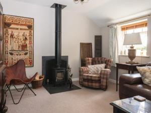 a living room with a wood stove and a couch at 1 Church Barns in Great Driffield