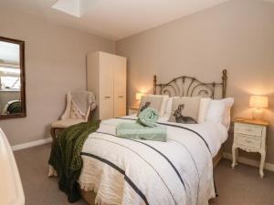 a bedroom with a large bed and a chair at 1 Church Barns in Great Driffield