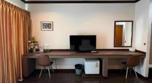 a desk with a computer and two chairs in a room at The Grace Residence in Surin