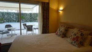 a bedroom with a bed and a balcony with a table at Residence Club Inn in Nice