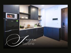 a kitchen with blue cabinets and a black refrigerator at Saigon Serene - SOHO Residence - Stay in District 1 in Ho Chi Minh City