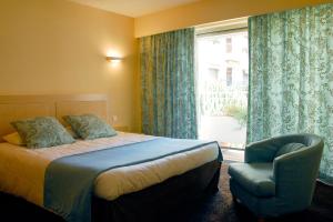 a bedroom with a bed and a chair and a window at Residence Club Inn in Nice