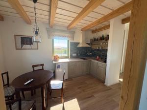 a kitchen with a table and a dining room at Levendula Apartman in Buzsák