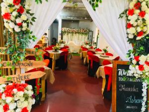 a restaurant with tables and chairs with red and white flowers at The Heaven Sorabora in Mahiyangana