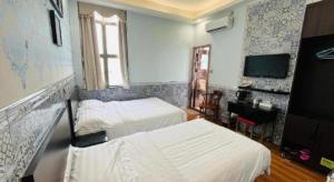a hotel room with two beds and a flat screen tv at Hou Kong Hotel in Macau