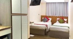 a small room with two beds and a kitchen at Metroplace Boutique in Hong Kong