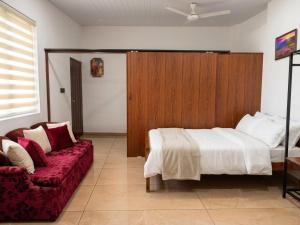 a bedroom with a bed and a couch at Tranquil Tents in Trivandrum